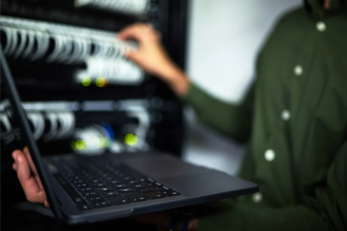 Server room maintenance, laptop and technician at work for cybersecurity