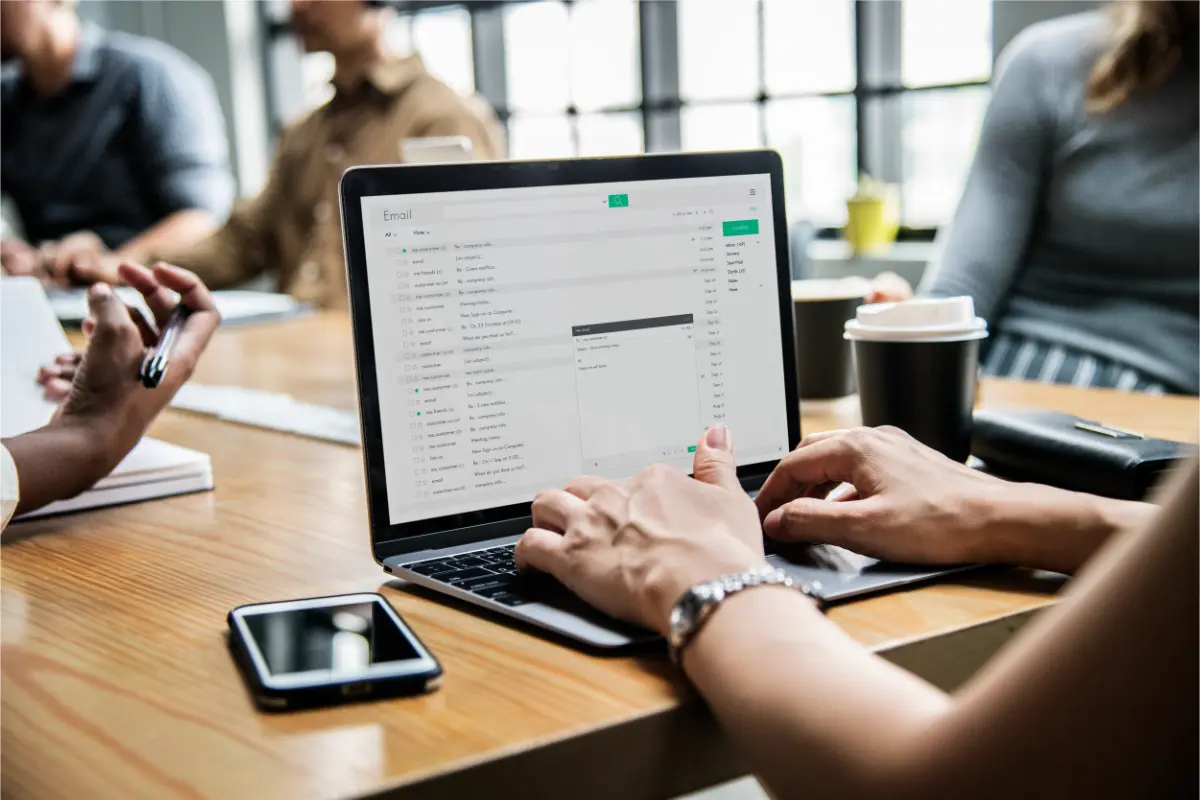 Woman checking her email in a meeting with security filter